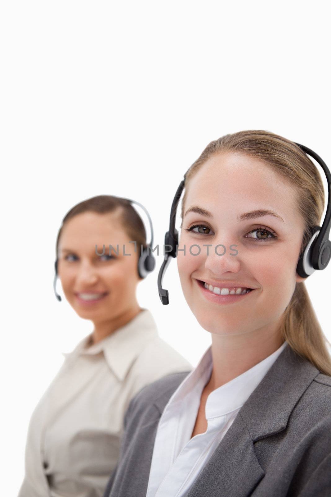 Portrait of young operators using headsets against a white background