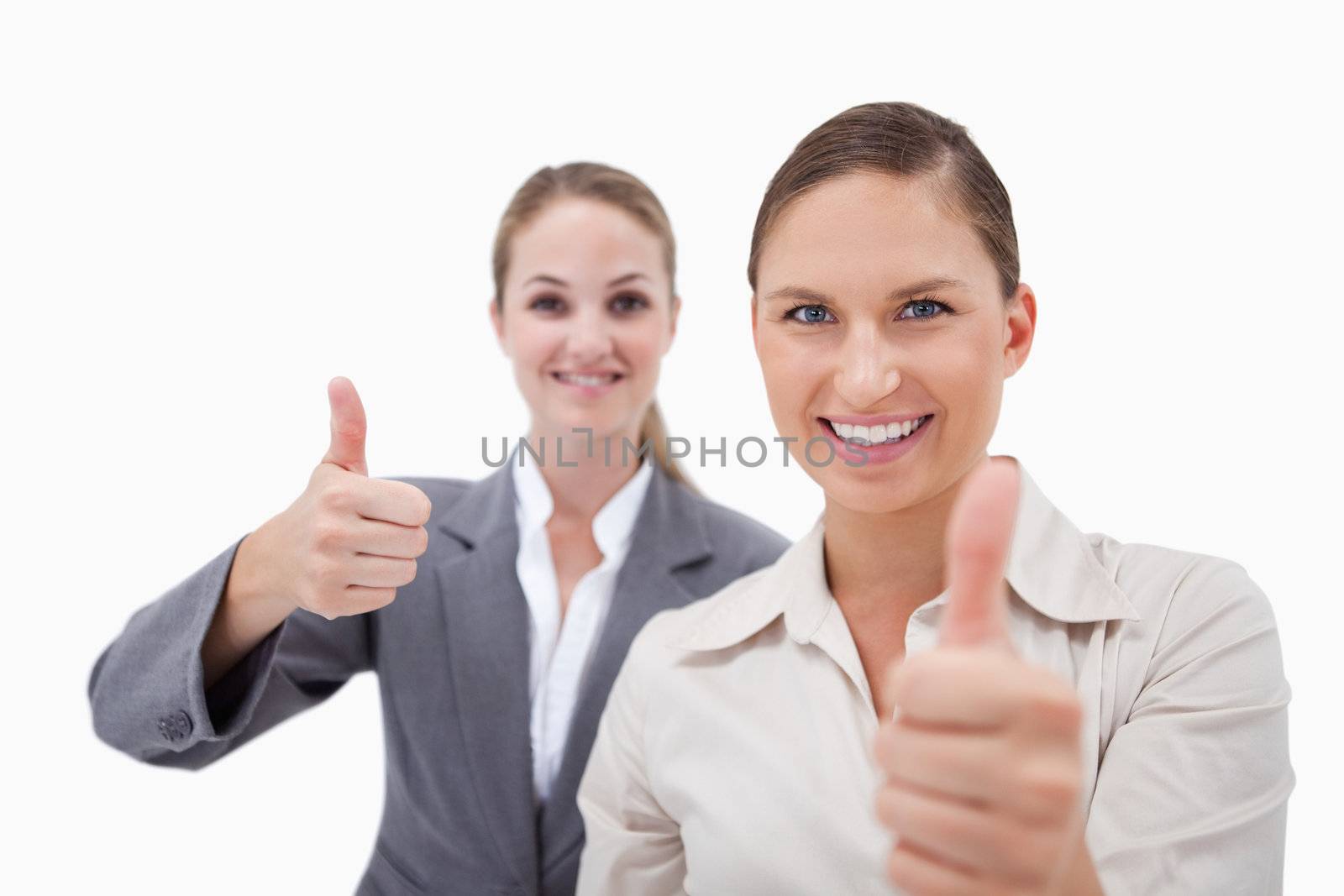 Smiling sales persons posing with the thumb up against a white background