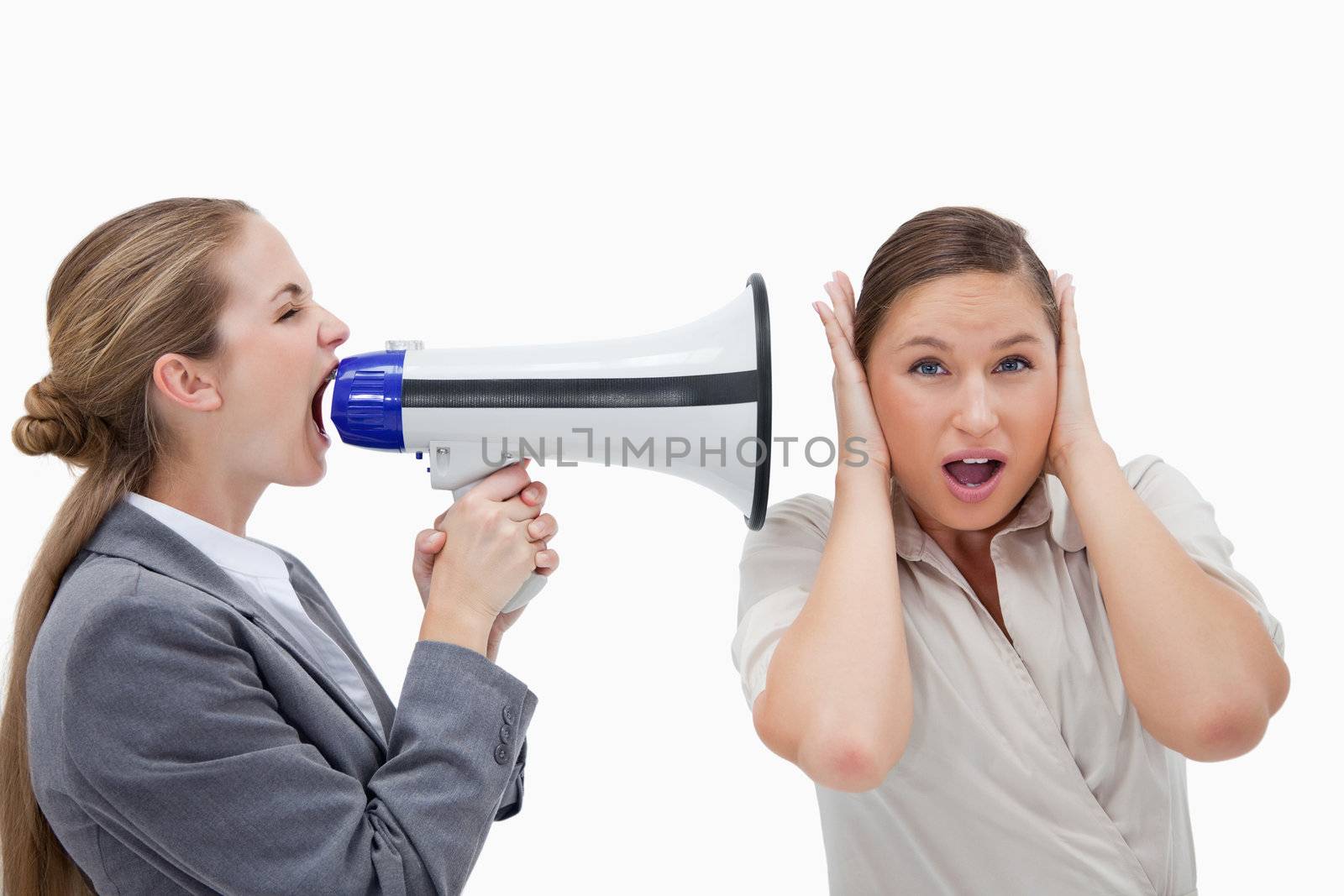 Businesswoman yelling at her coworker through a megaphone against a white background