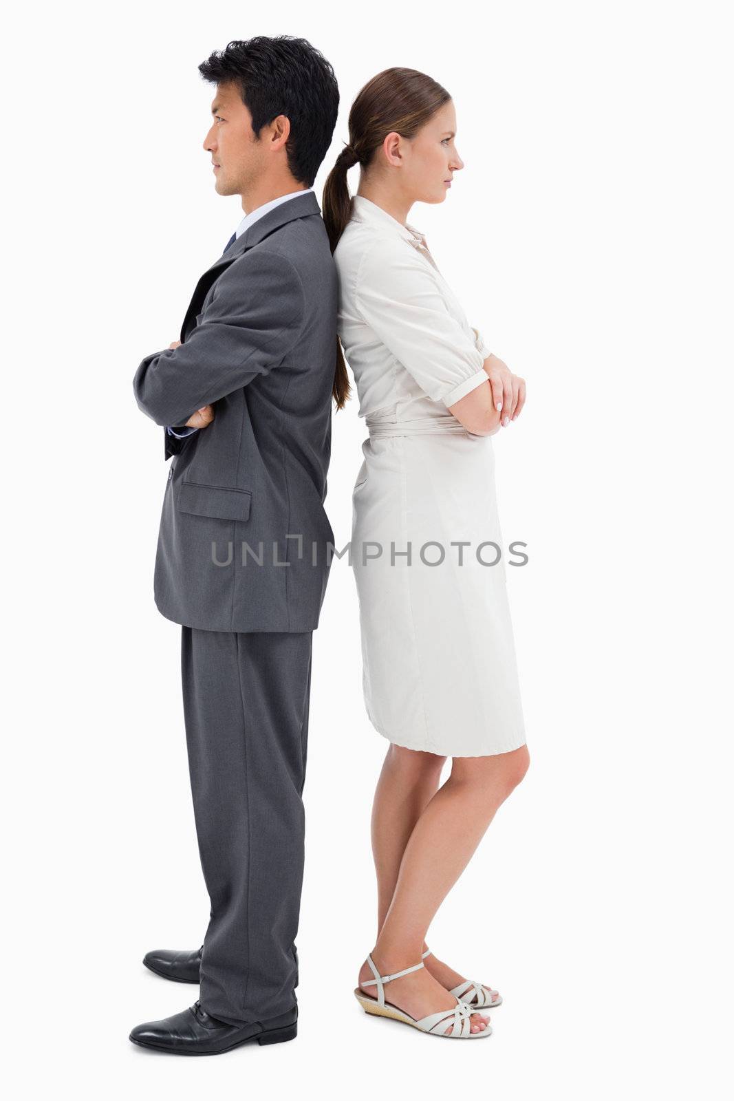 Portrait of serious business people standing back to back against a white background