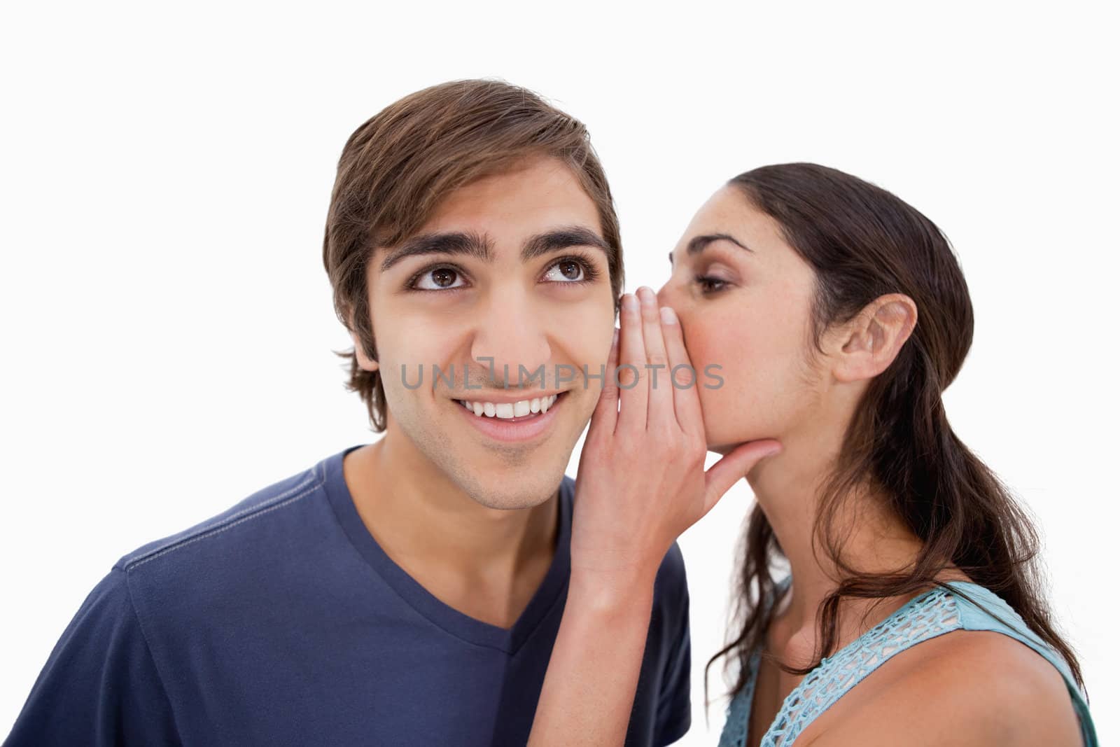 Charming woman whispering something to her fiance against a white background