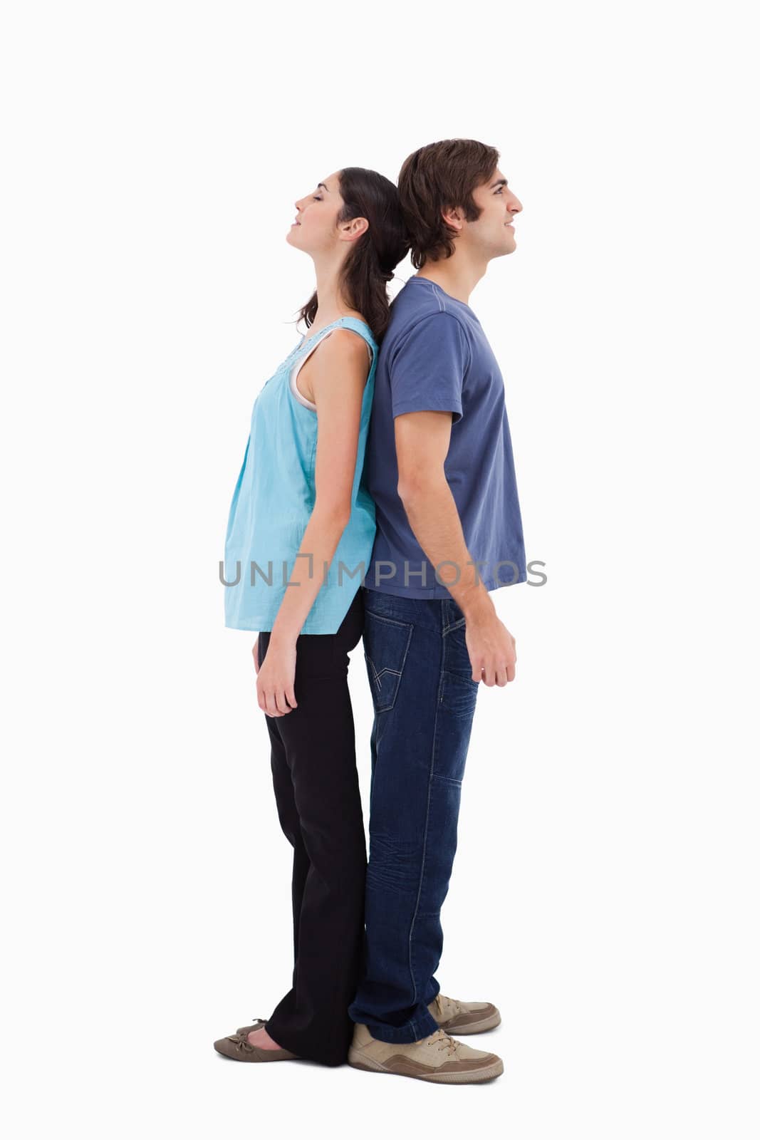 Portrait of a couple standing back to back against a white background