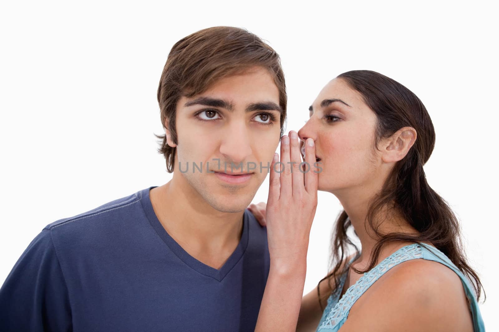 Woman whispering something to her fiance against a white background