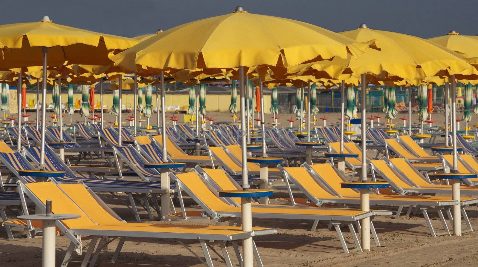 Umbrellas and sun beds on the beach in the glow of the setting sun