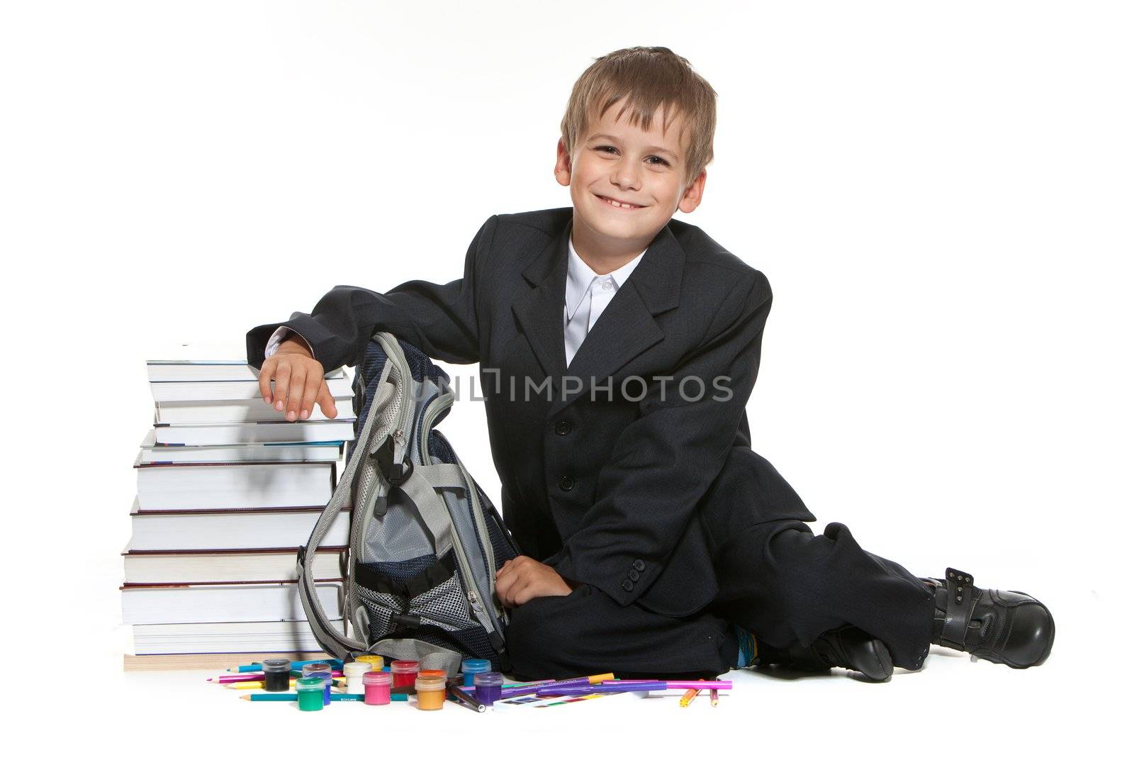 Boy, pencils, paints and books isolated on a white background