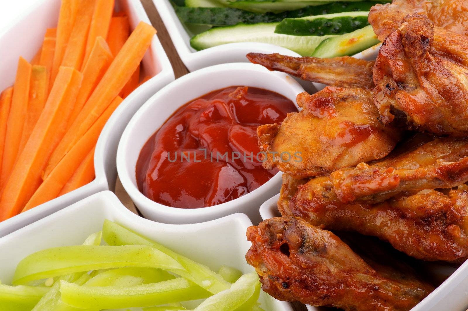 Chicken Wings Platter with Barbecue Dressing, Cucumber, Bell Pepper and Carrot Sticks closeup