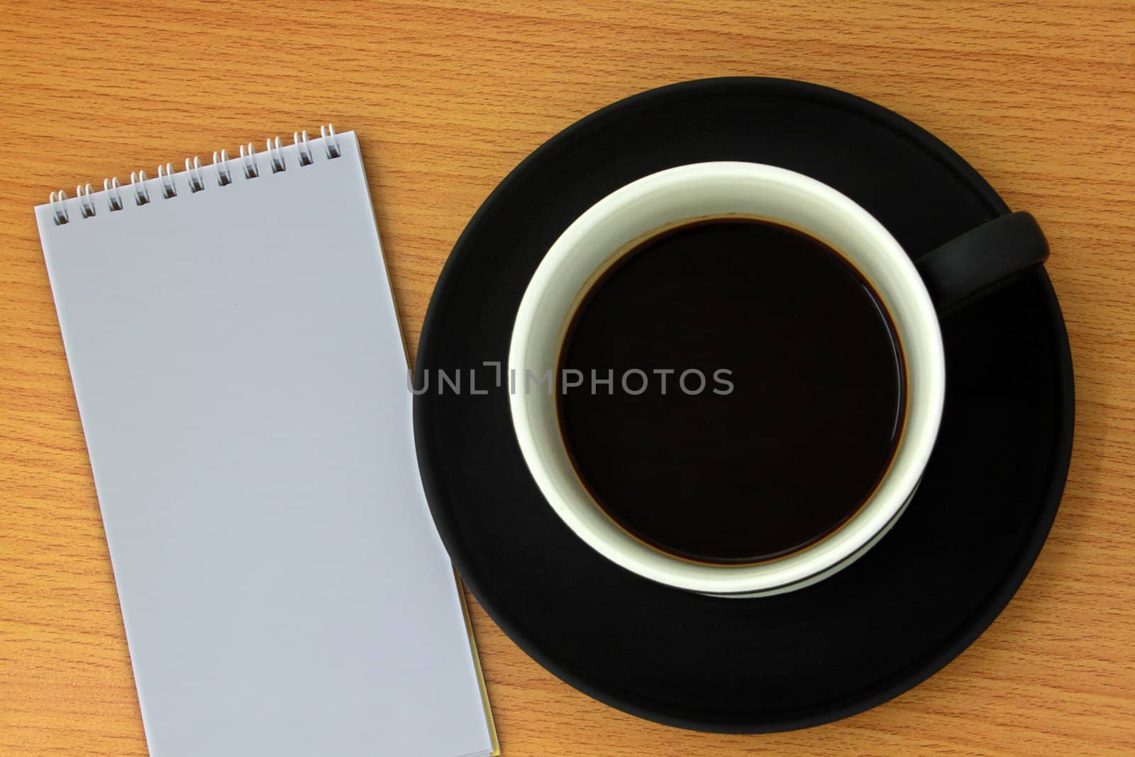 Coffee cup and white notebook