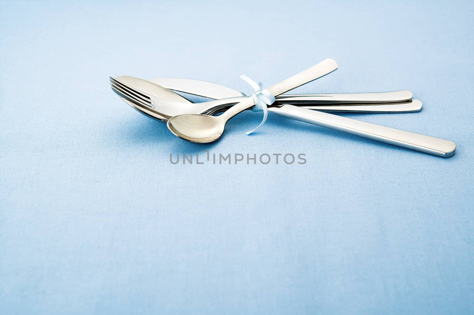 A silver wear set on blue tablecloth