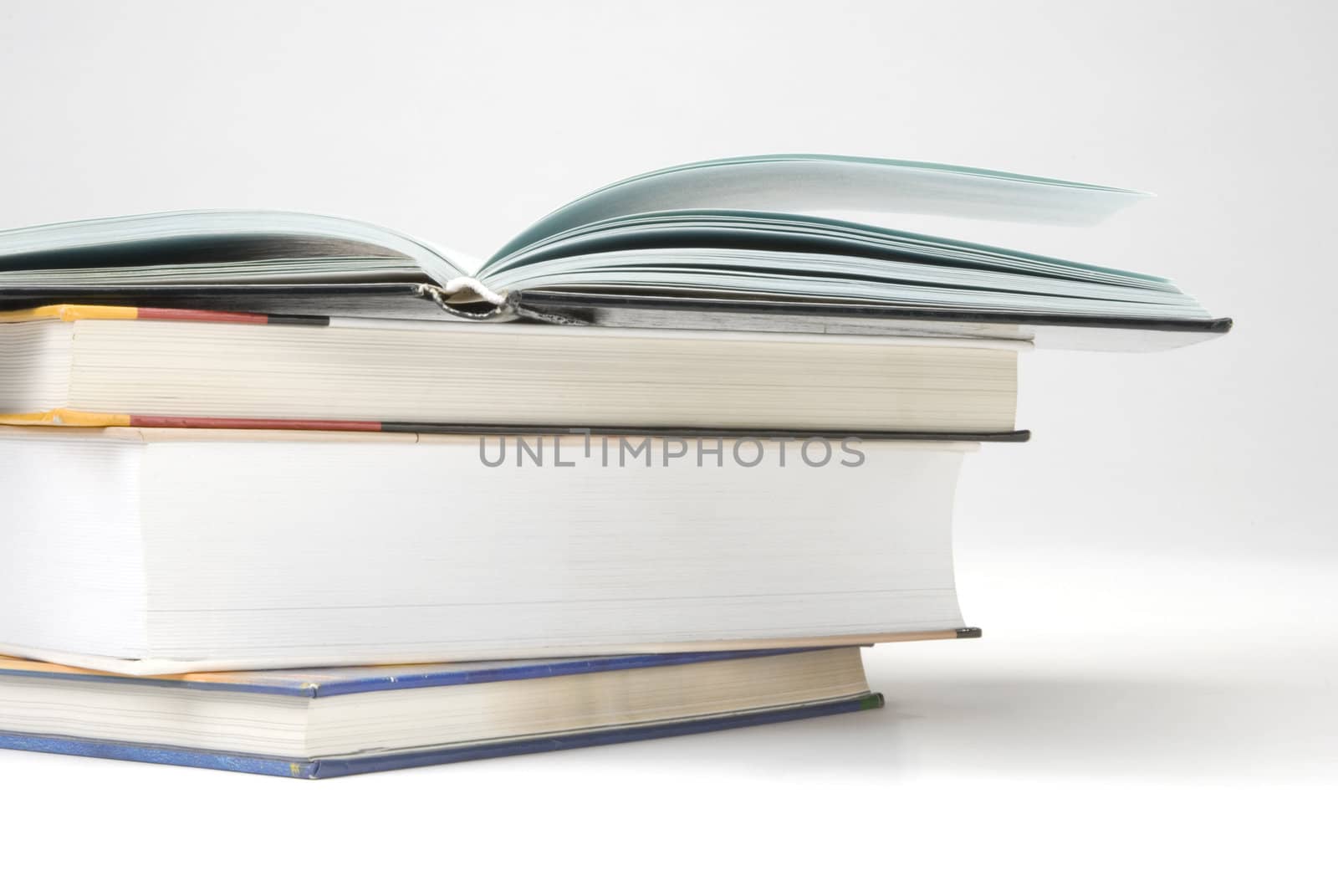 Three book and one opened on white background