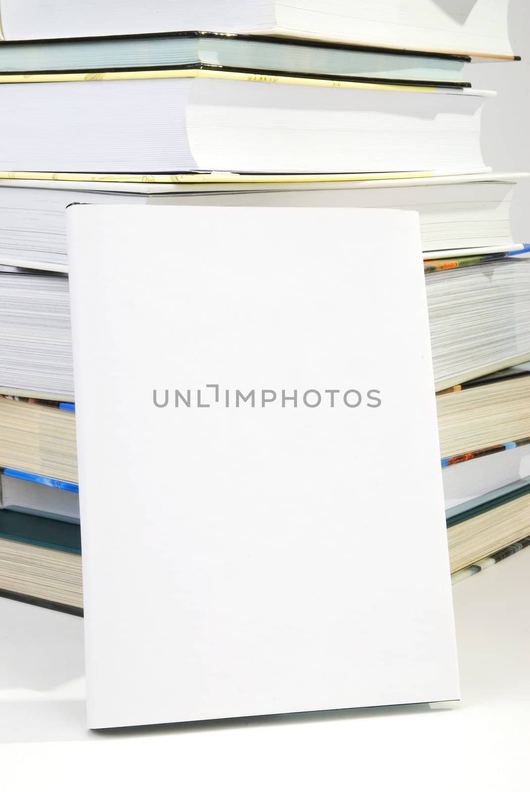 Blank book cover w background of pile of books