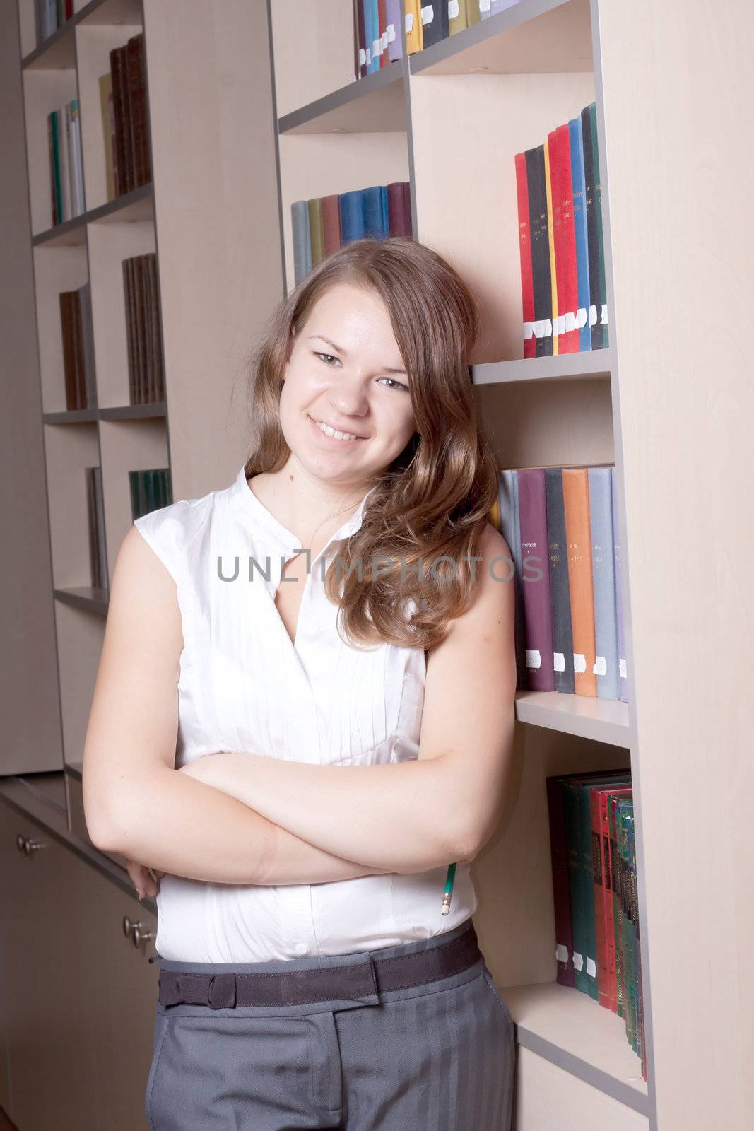 Beautiful girl in the library among the books