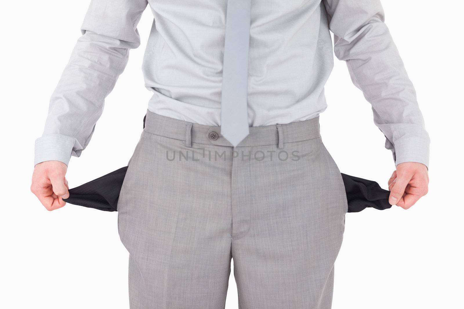Businessman showing his empty pockets against a white background
