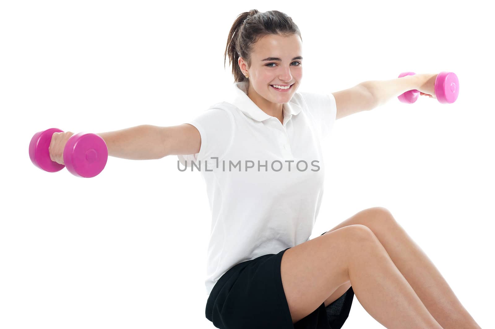 Healthy exercising fitness caucasian teenager holding dumbbells and stretching arms sideways