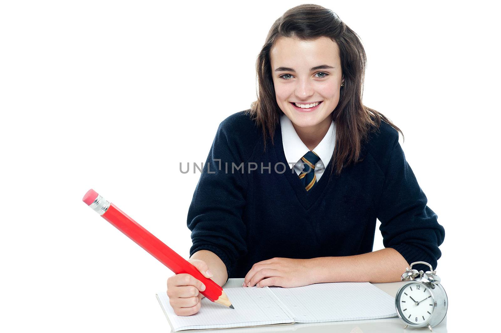 Profile shot of smiling school girl taking down notes, holding big red pencil