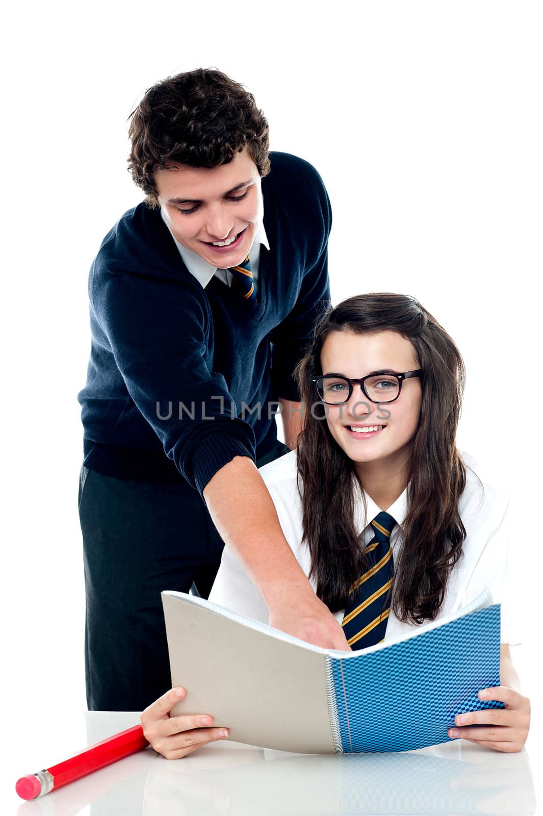 Boy pointing out the answer to the bespectacled girl in her book. All on white background