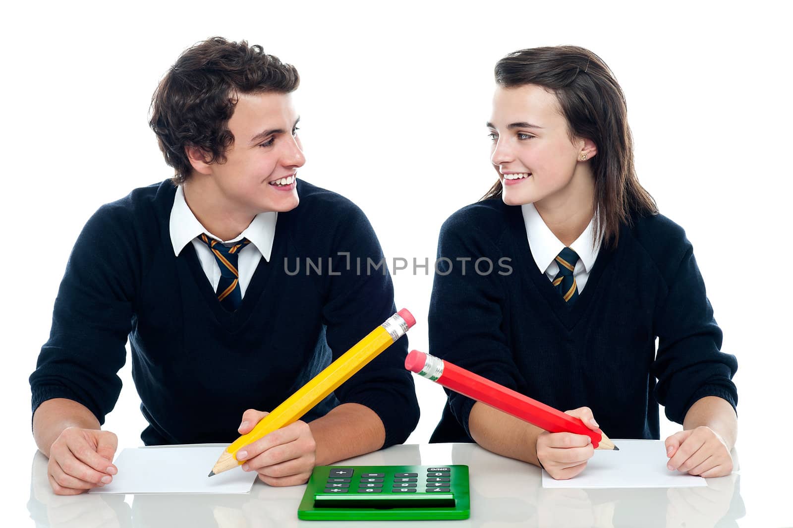 Classmates looking at each other and discussing the correct answer before writing