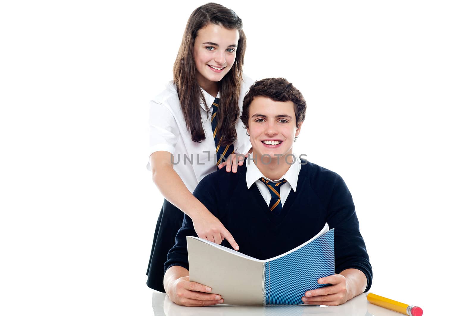 Girl pointing out the answer to her classmate. Cheerfully posing in front of camera