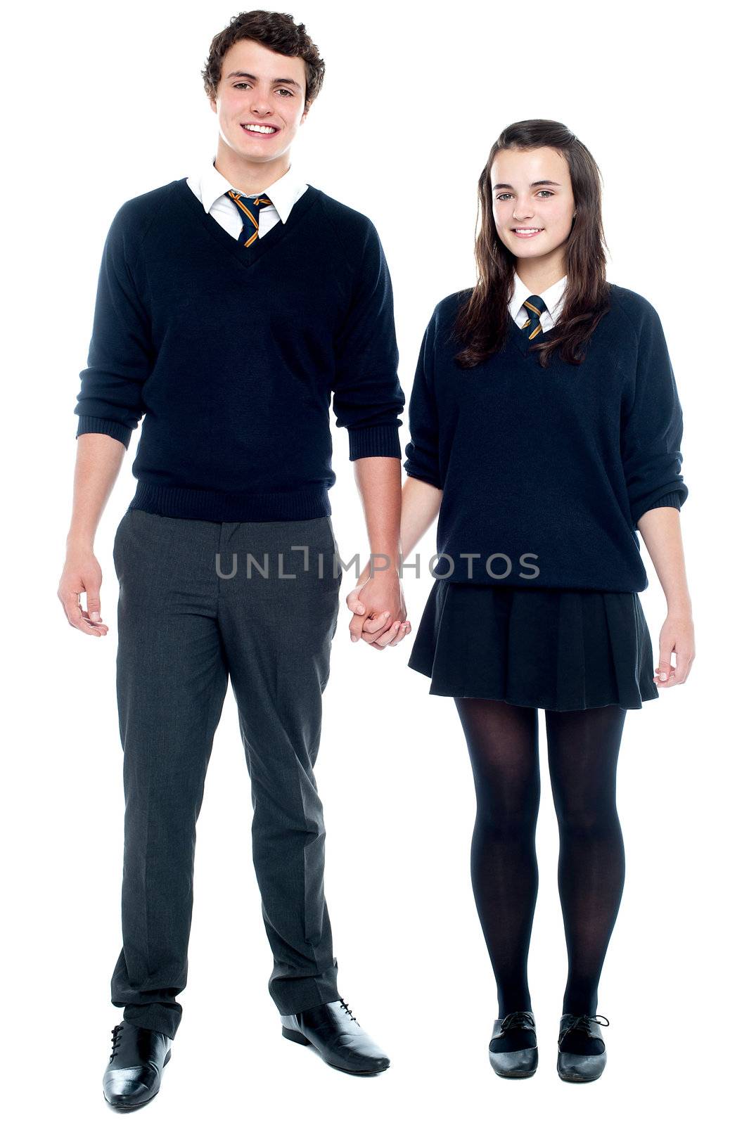 Full length portrait of a school friends in uniform holding hands