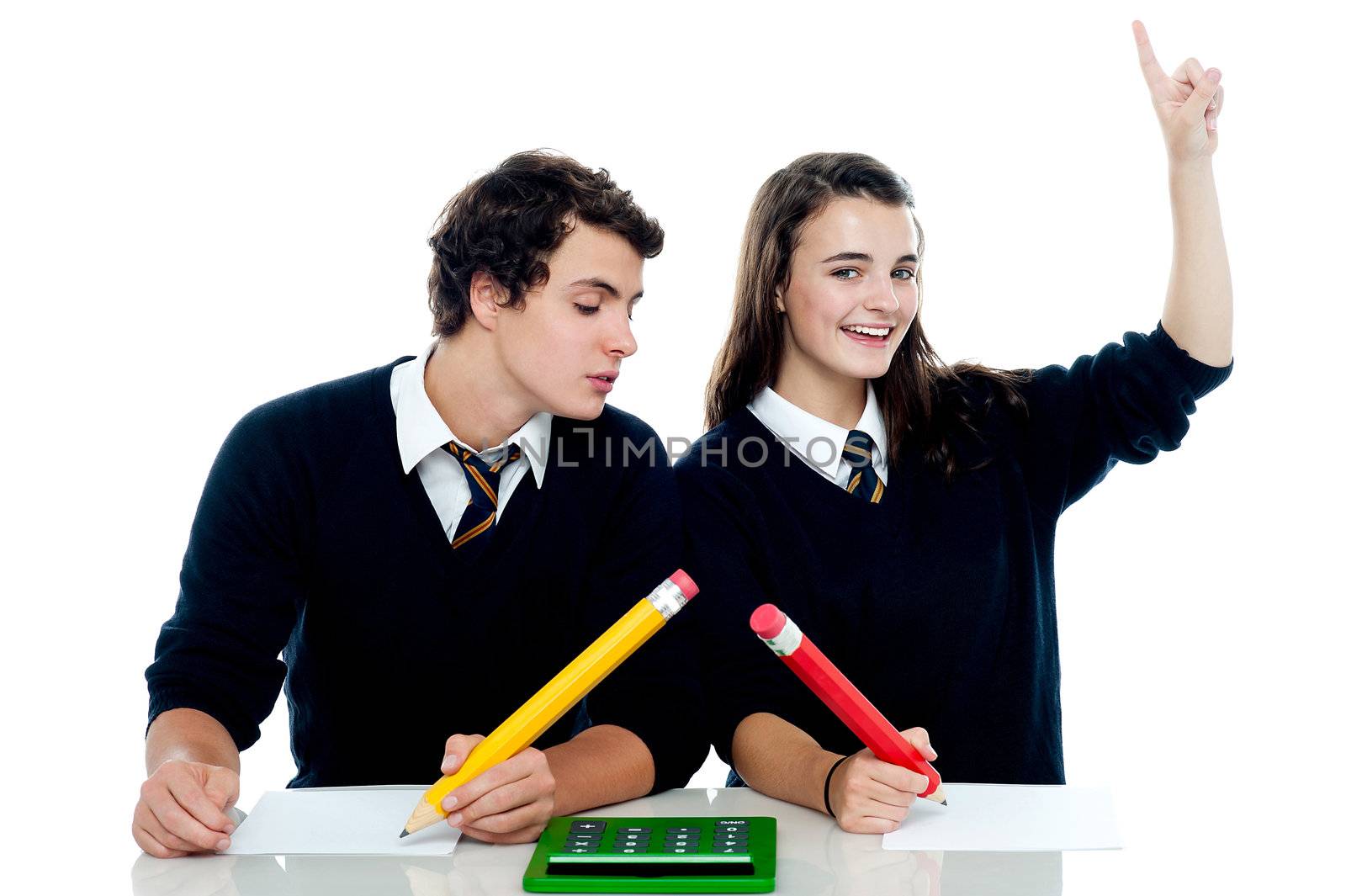 School boy peeping into the girls answer sheet by stockyimages