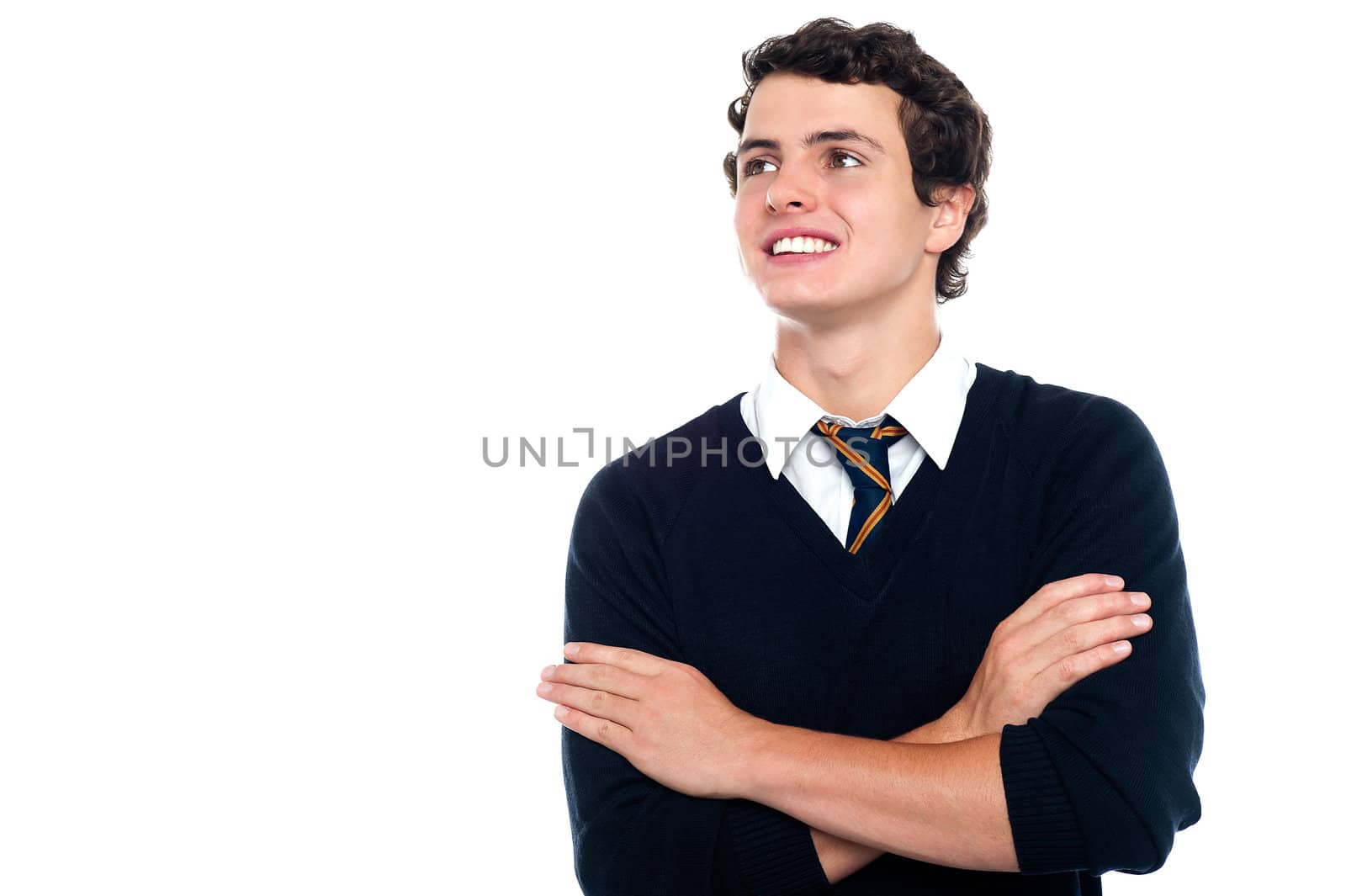 An attentive youngster looking at the board with his arms crossed