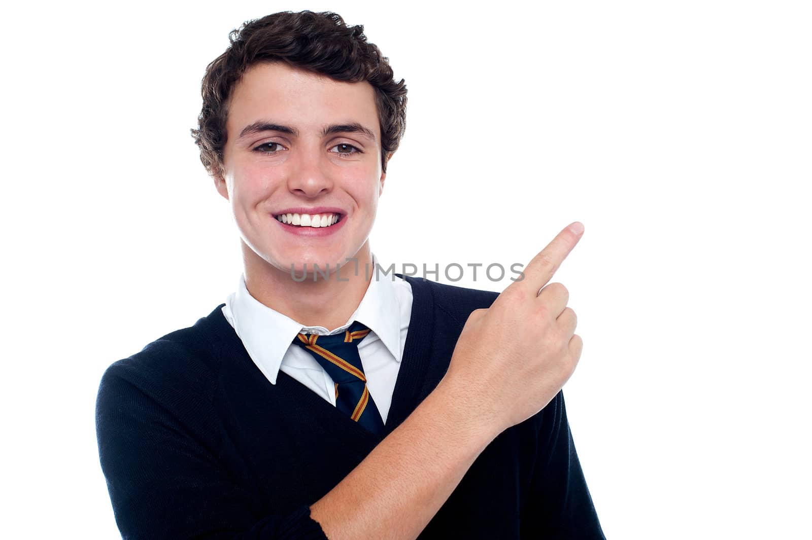 Cheerful schoolboy pointing at copy space area isolated over white background