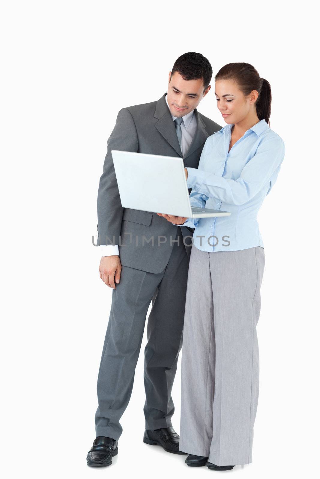 Business partner looking at a notebook together against a white background