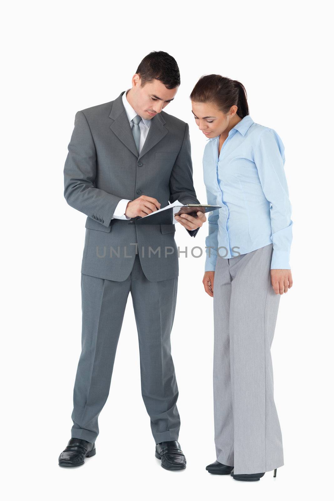 Business partner having a look at a clipboard together against a white background