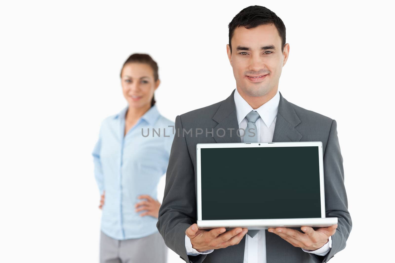 Businessman presenting laptop with businesswoman in the background against a white background