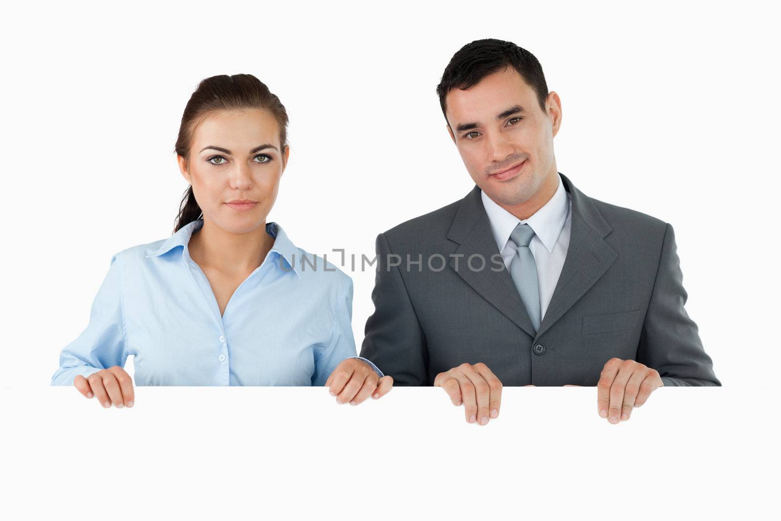 Business partners holding sign against a white background