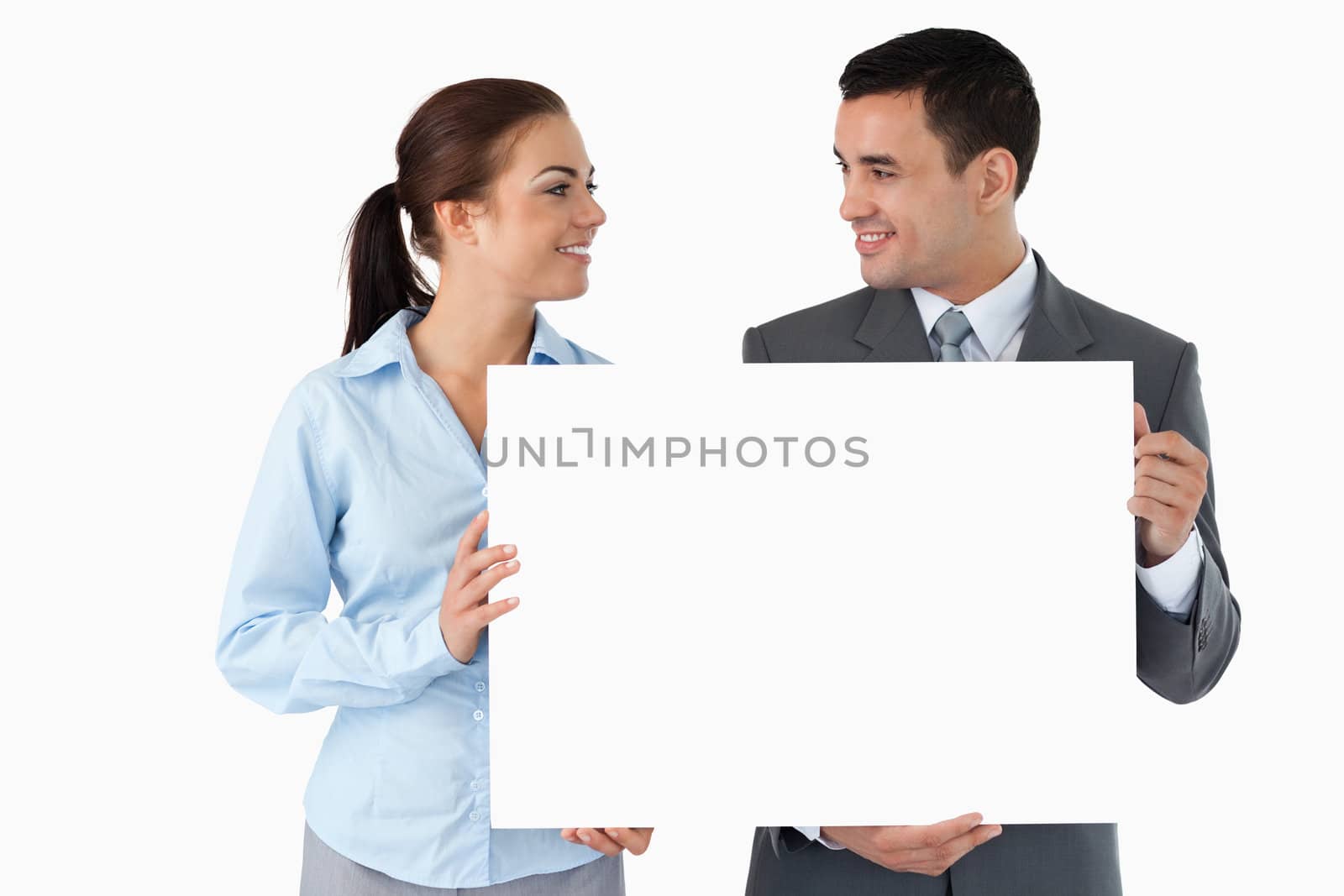 Young business partners presenting sign against a white background