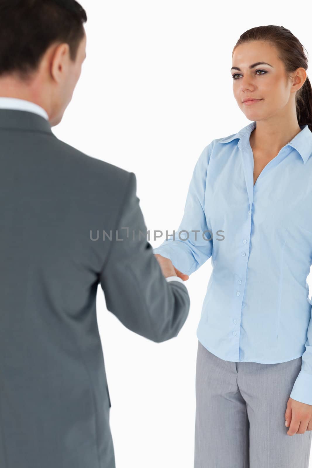 Young business partners agreeing on a deal against a white background