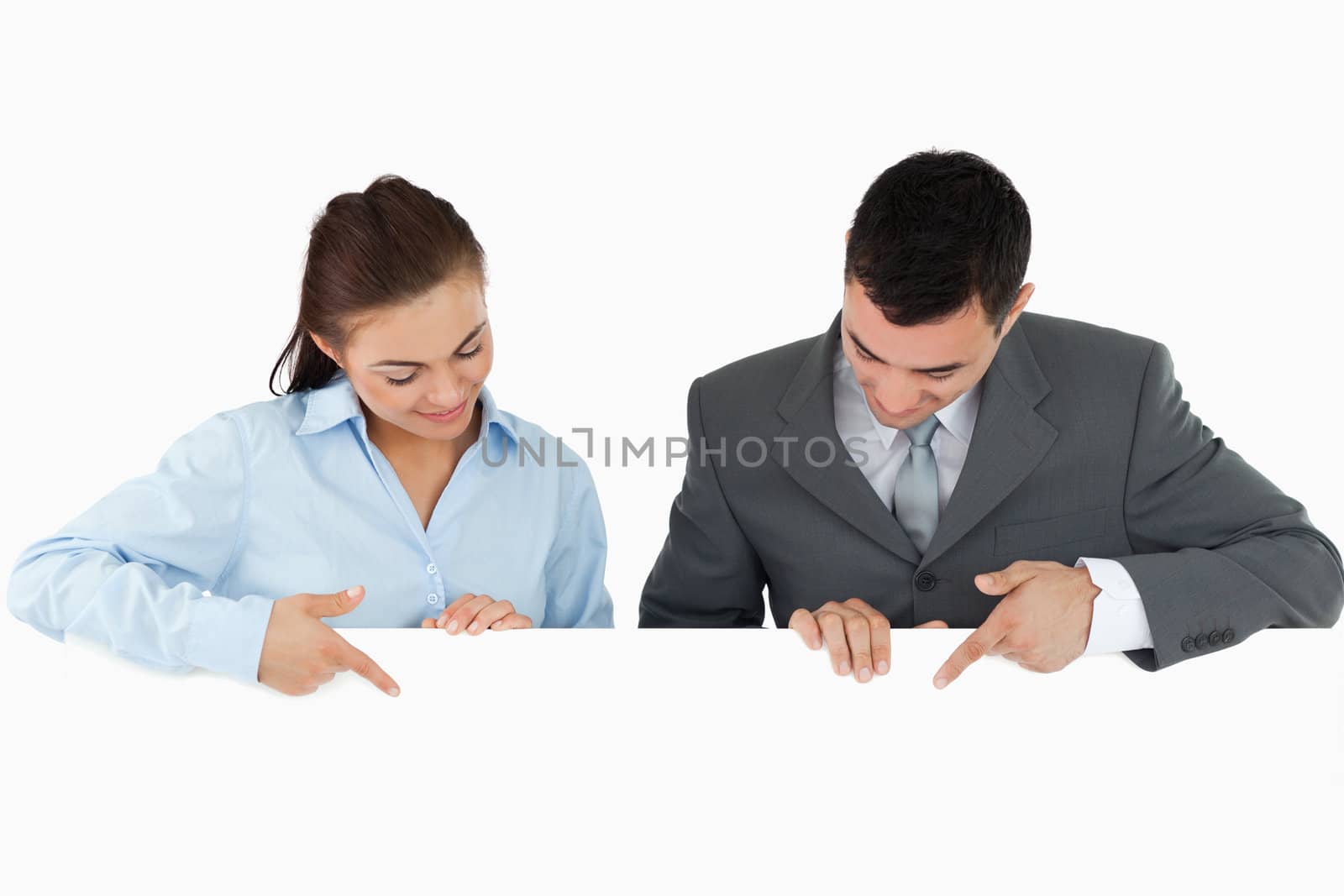 Business partners looking and pointing at sign they are holding against a white background