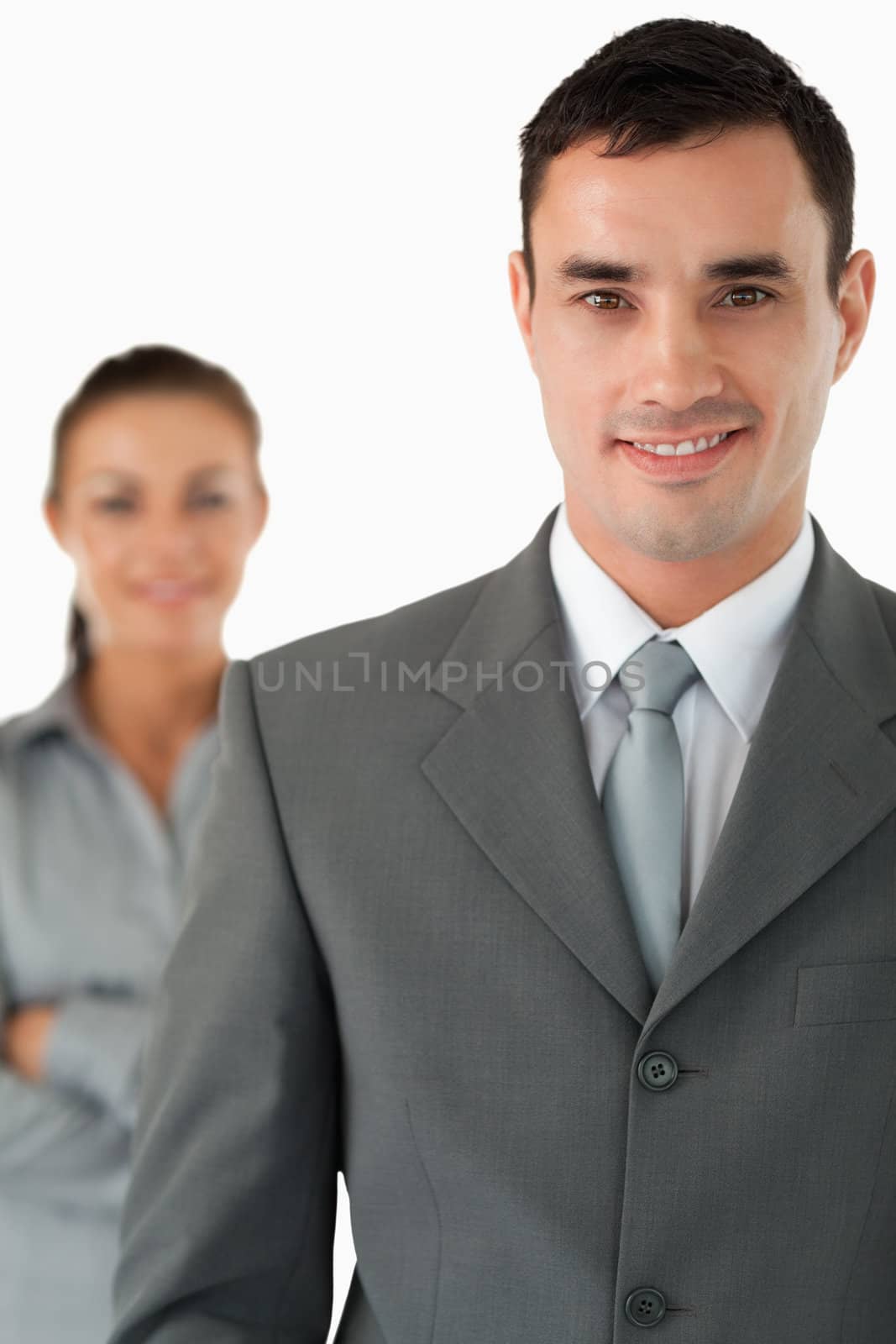 Close up of smiling businessman with colleague behind him against a white background