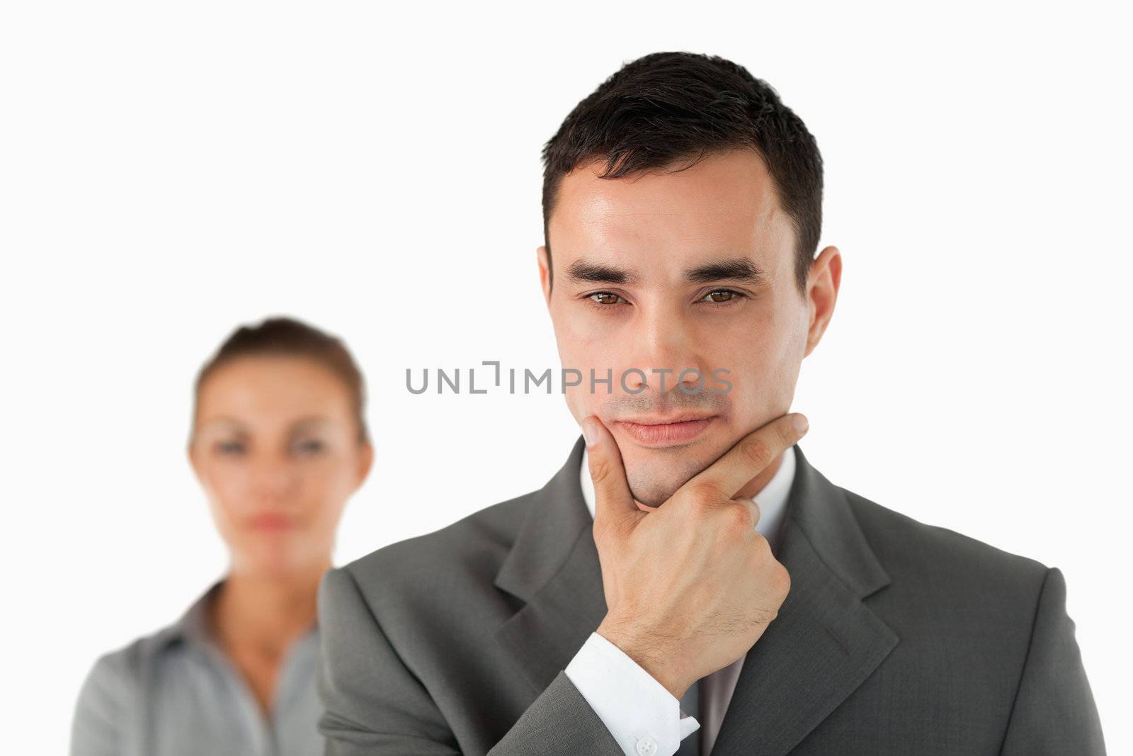 Close up of businessman in thoughts with colleague behind him against a white background