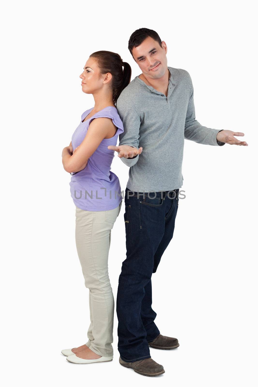 Young male doesn't know what's wrong with his girlfriend against a white background