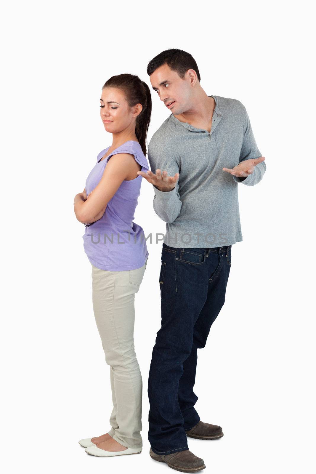 Young male asking his girlfriend for forgiveness against a white background