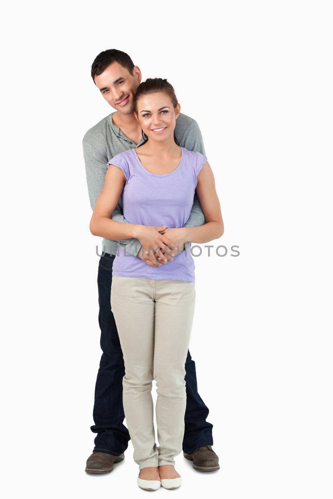 Young male holding his girlfriend against a white background