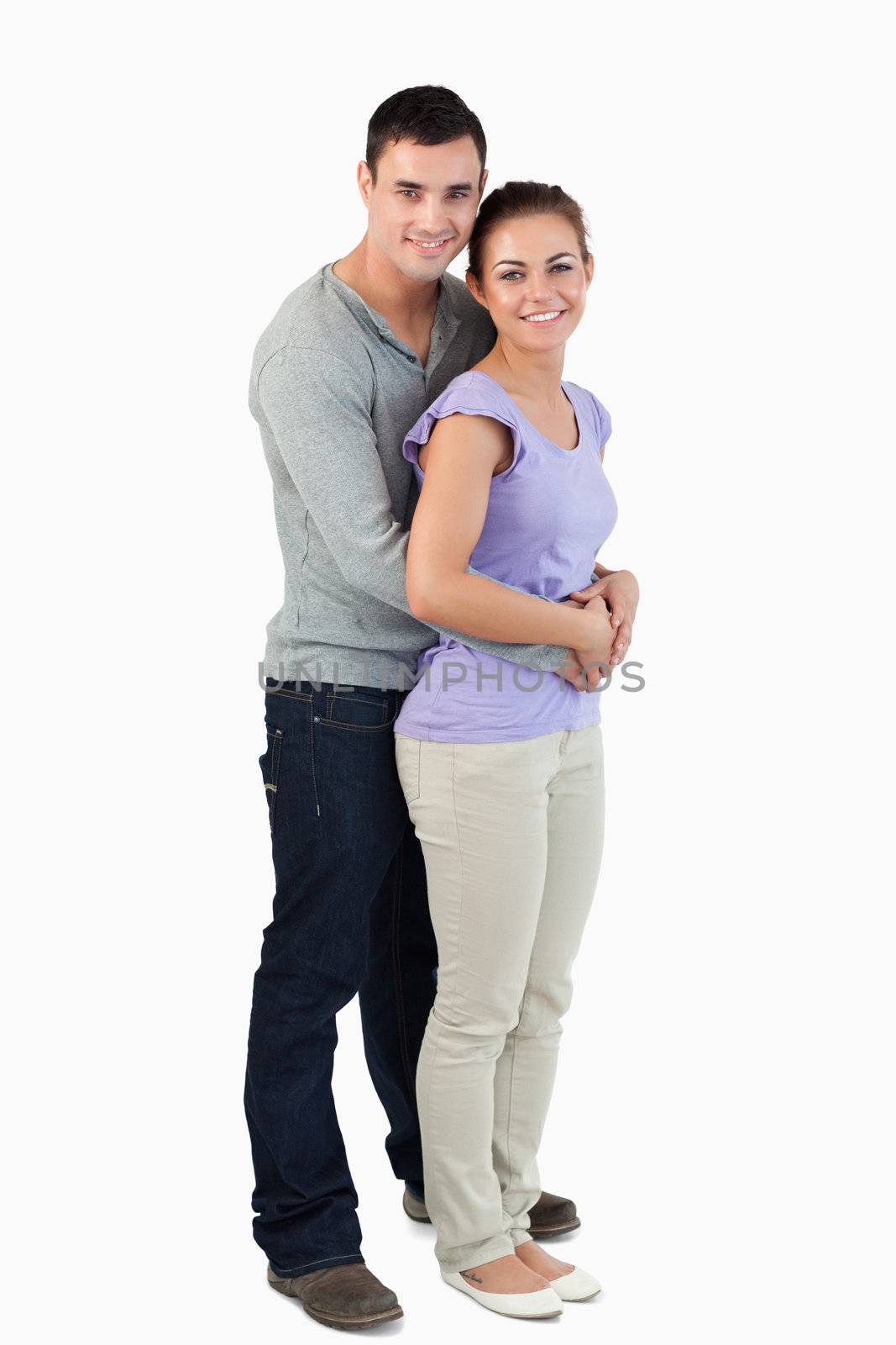 Side view of young male holding his girlfriend against a white background