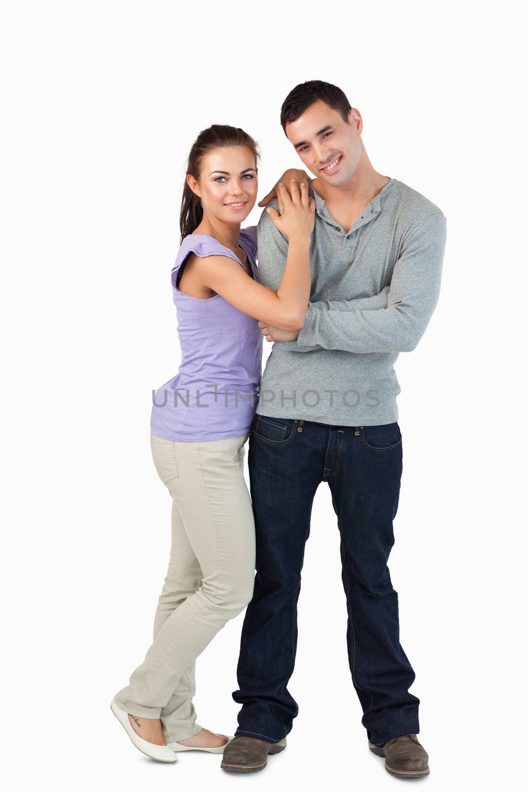 Young couple standing close together against a white abckground