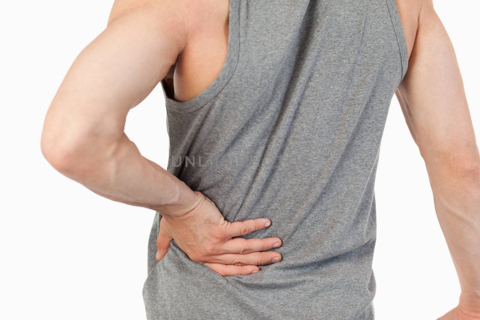 Male hands touching own spine against a white background