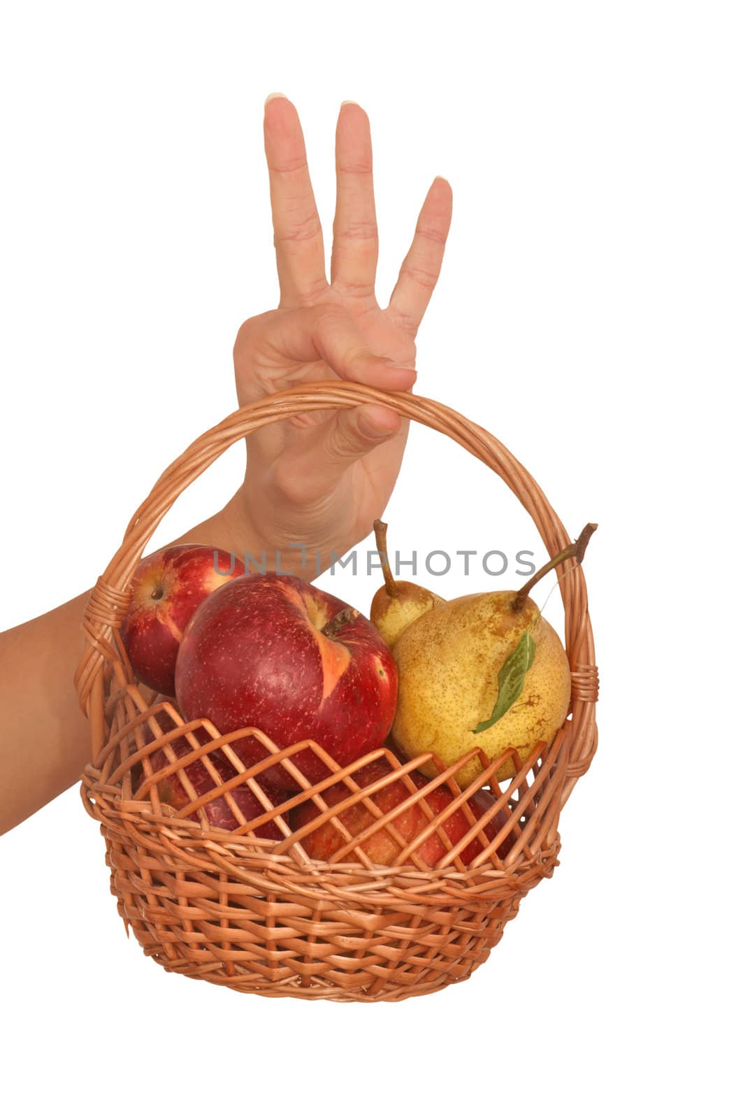 Basket with yellow pears and red apples in the hand