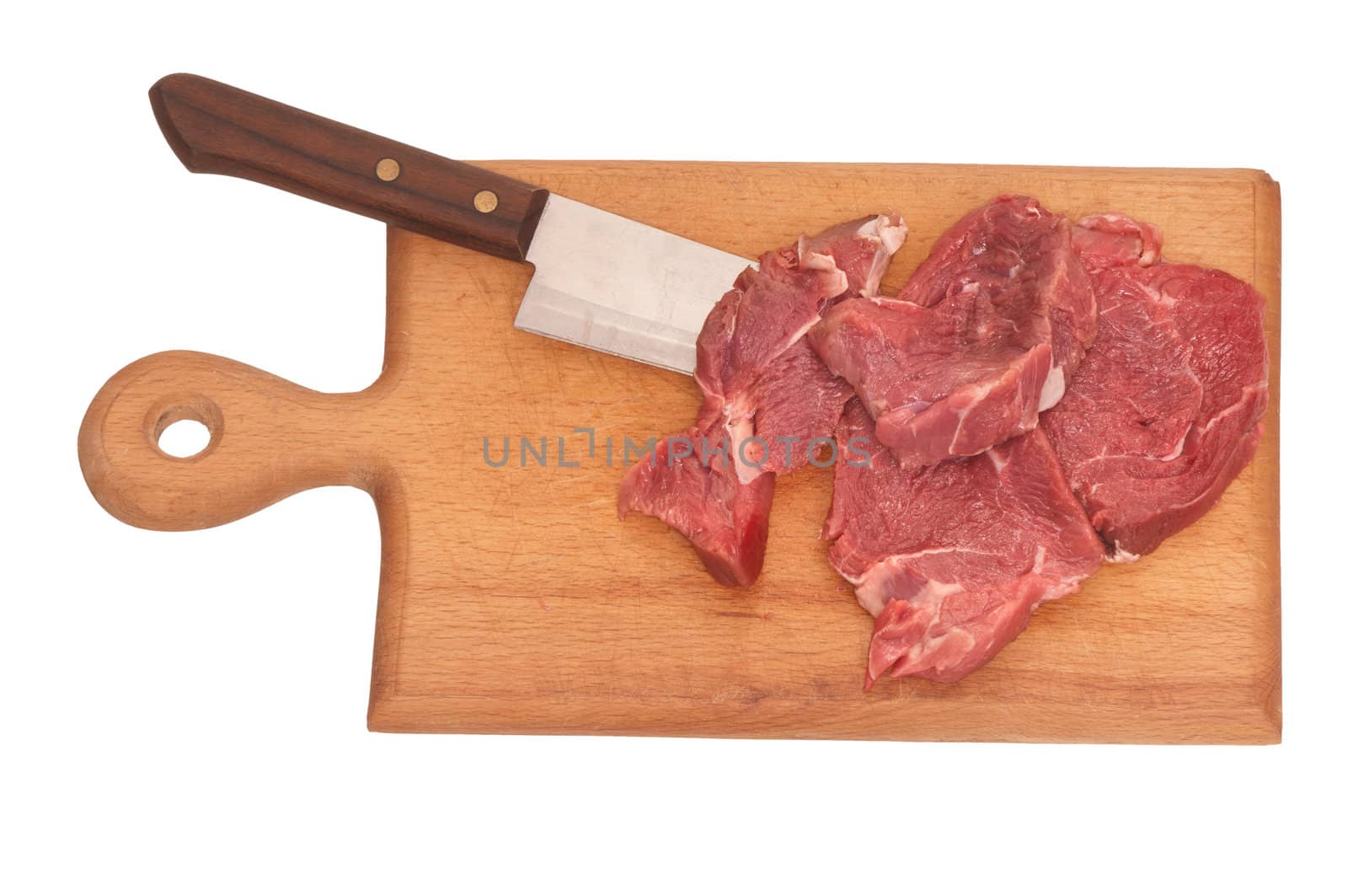 Slices of the meat on the board with knife on the kitchen