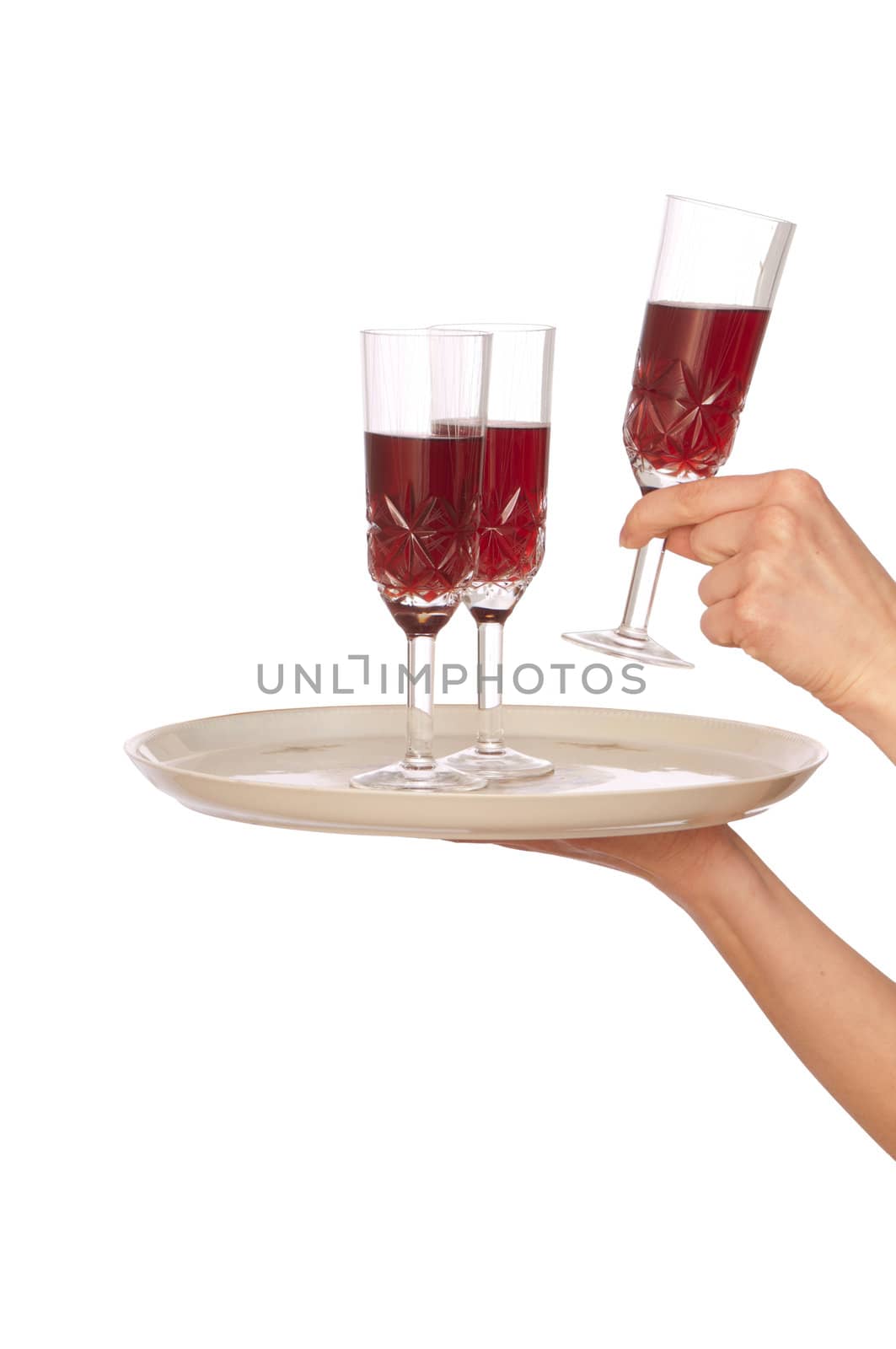 A waiter takes a glass of champagne from a tray with three glasses