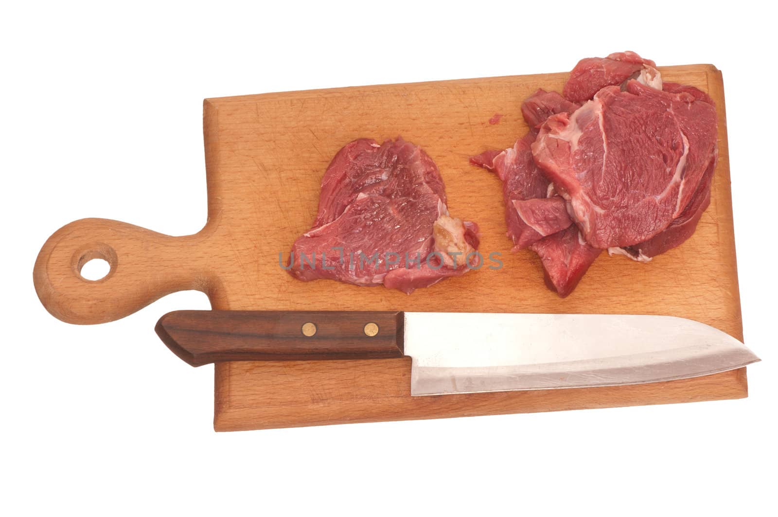 Slices of the meat on the board with knife on the kitchen