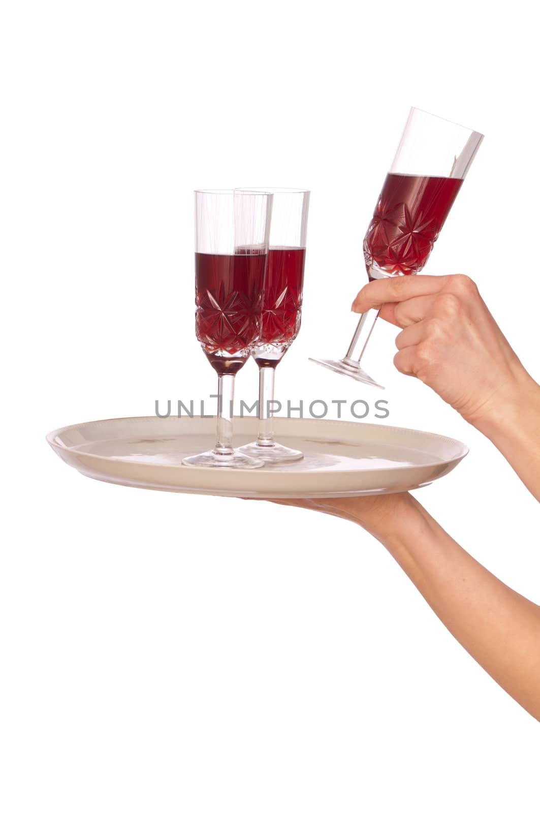 A waiter takes a glass of champagne from a tray with three glasses