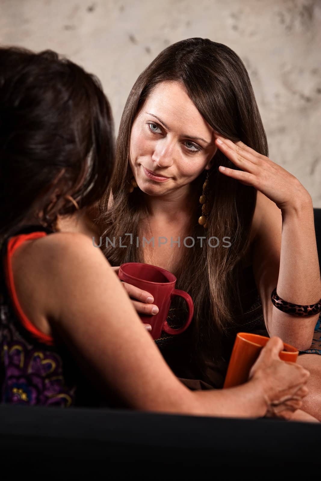 Concerned lady with hand on head listening to friend