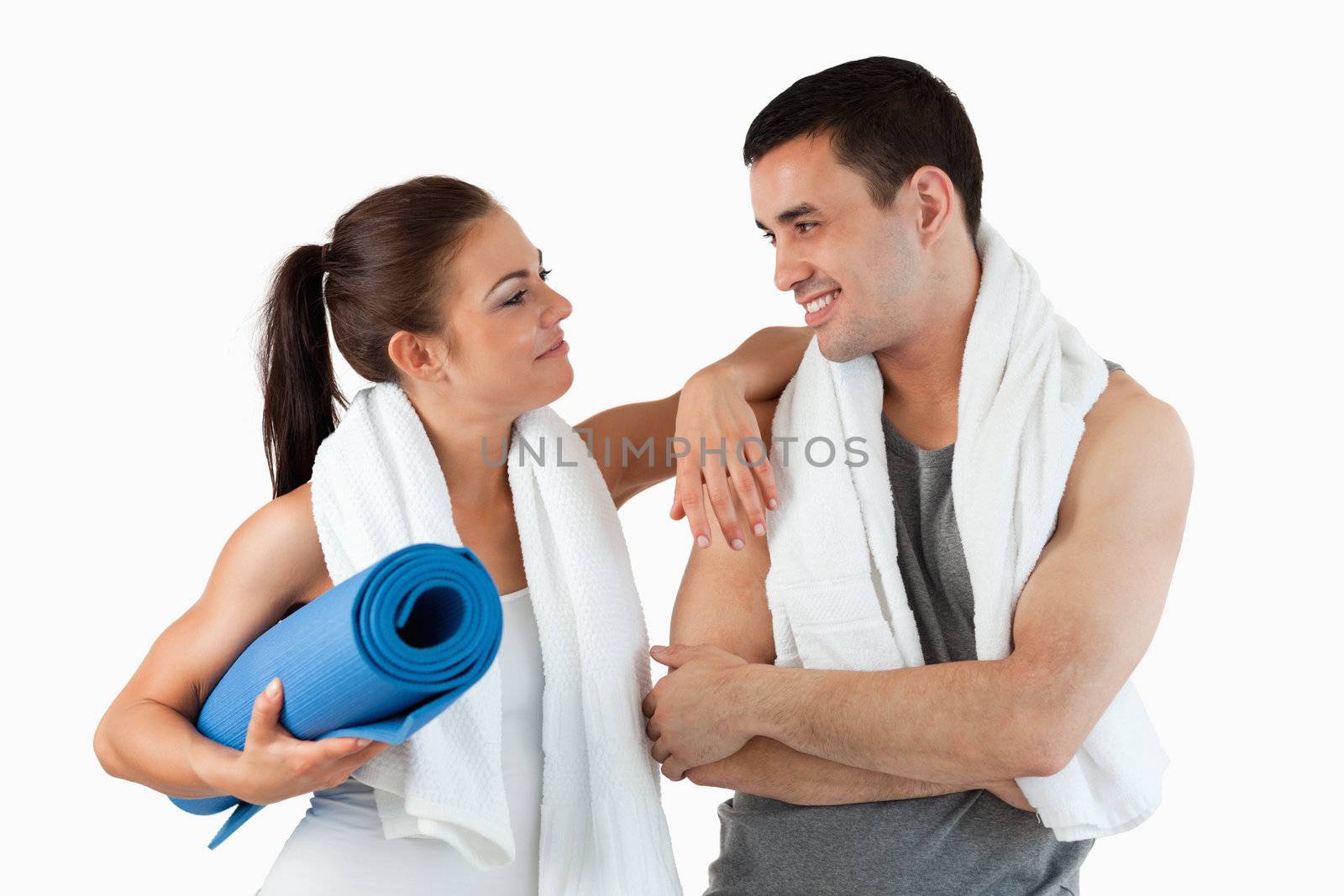 Healthy couple going to practice yoga against a white background