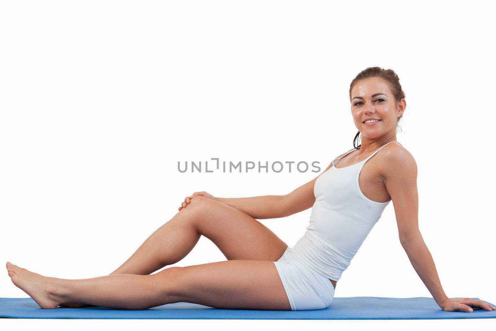 Woman lying on a foam mat against a white background