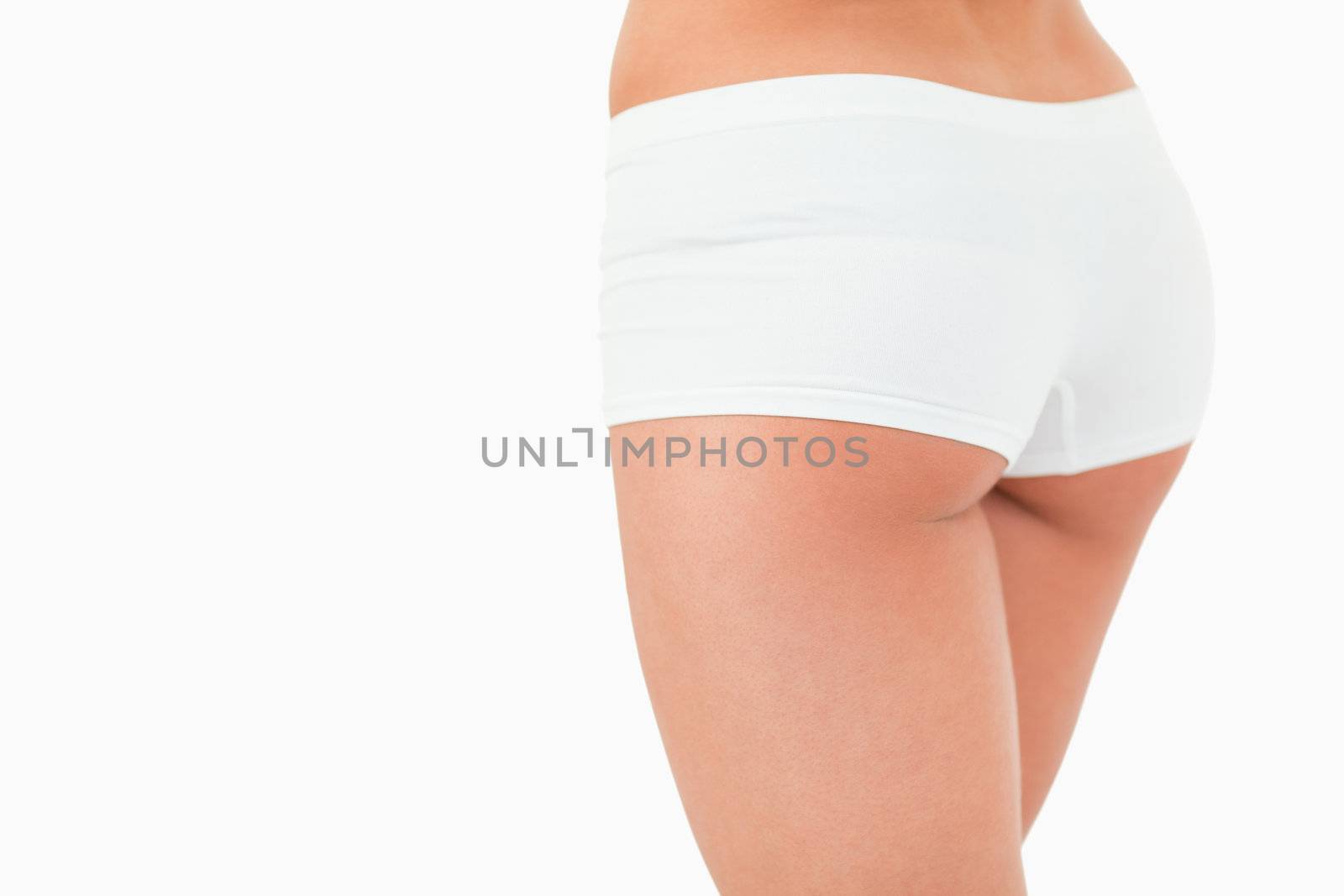 Close up of feminine buttocks against a white background