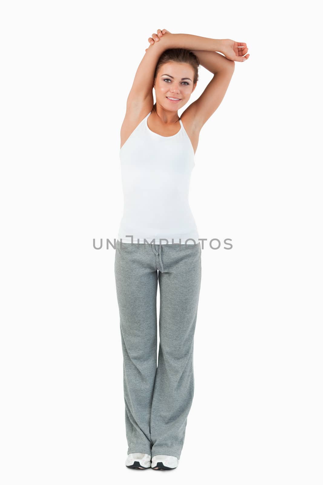 Portrait of a woman stretching her arms against a white background